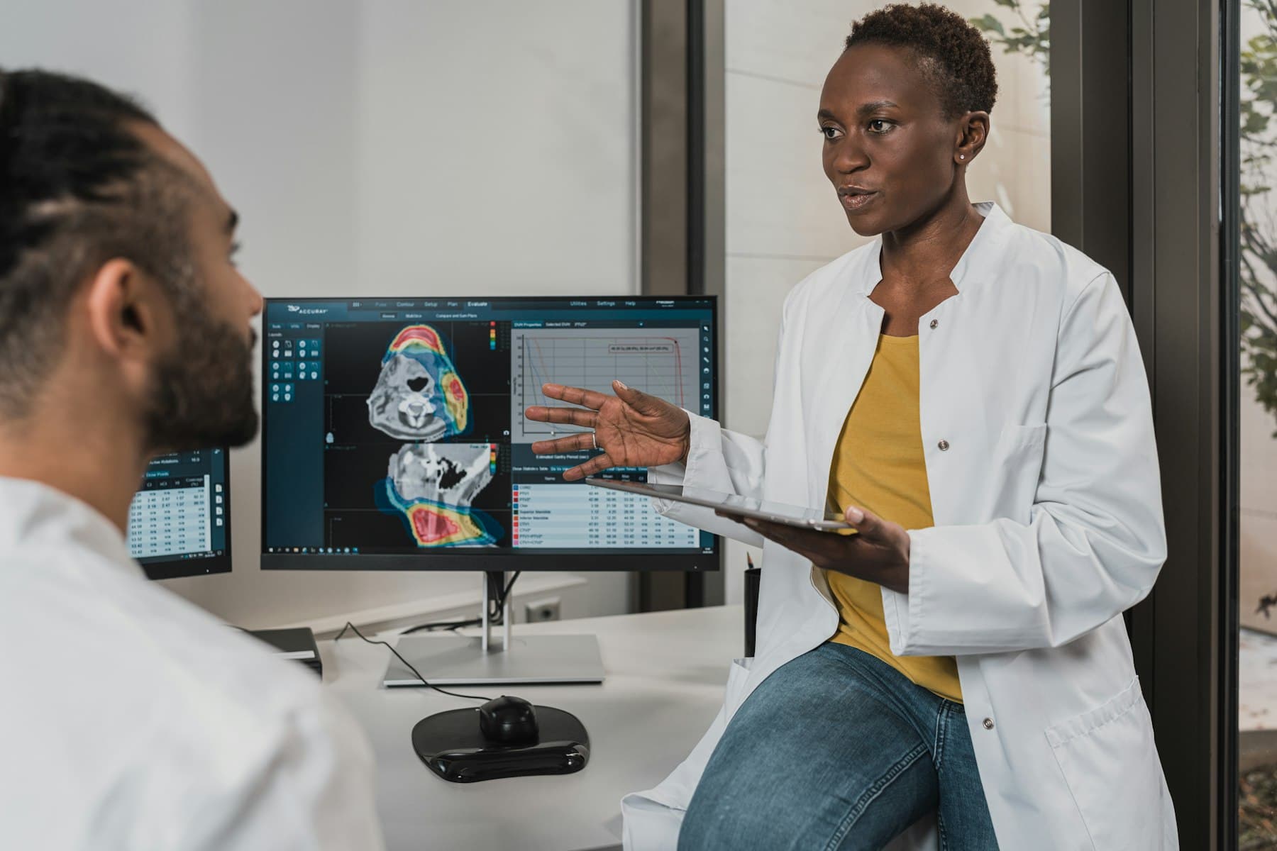 Two clinicians reviewing diagnostic imaging on clinic monitors